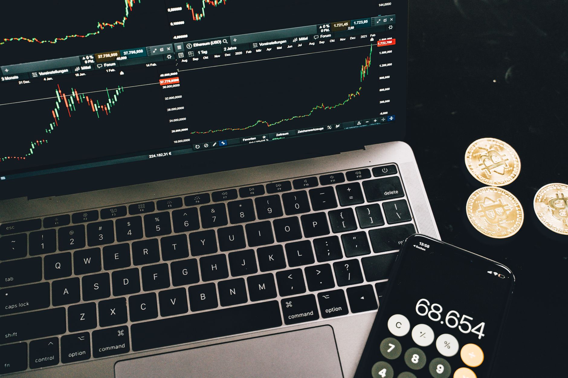 Computer monitor showing cryptocurrency candlestick charts and order book at night.